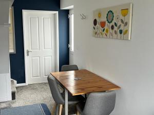 a dining room with a wooden table and two chairs at Godrevy Lighthouse View, Carbis Bay, St Ives, free parking near beach in Carbis Bay