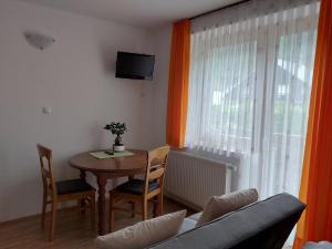 a living room with a table and a couch and a window at Apartments and Rooms Martuljk in Kranjska Gora