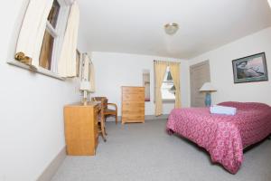 a bedroom with a bed and a table and a desk at Northwest Portland Hostel in Portland