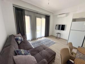 salon z brązową kanapą i telewizorem w obiekcie Villa Seray Datça w mieście Datça