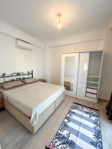 een slaapkamer met een bed, een spiegel en een tapijt bij Villa Seray Datça in Datca