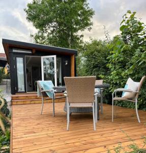 een terras met stoelen en een tafel en een huis bij Dejligt Tinyhouse i Gilleleje in Gilleleje