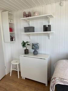 Un dormitorio con un escritorio con una planta. en Dejligt Tinyhouse i Gilleleje, en Gilleleje