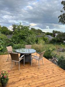 un patio con tavolo e sedie su un ponte di legno di Dejligt Tinyhouse i Gilleleje a Gilleleje