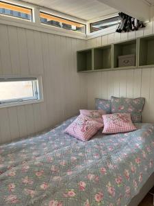 a bedroom with a bed with pillows on it at Dejligt Tinyhouse i Gilleleje in Gilleleje