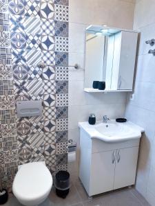 La salle de bains est pourvue de toilettes, d'un lavabo et d'un miroir. dans l'établissement Villa Seray Datça, à Datça