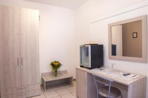 a room with a desk with a tv and a mirror at Residence Alberghiero Eolie in Lipari +102 photos