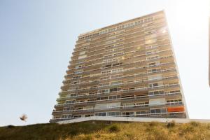 ein hohes Gebäude auf einem Hügel in der Unterkunft Palace Hotel Zandvoort in Zandvoort