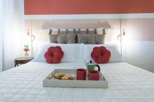a tray of donuts on a white bed with red pillows at Vaccaj Home cultura musica e mare a Pesaro by Yohome in Pesaro