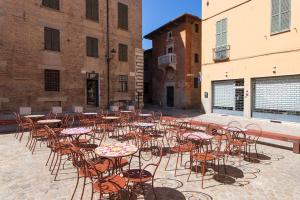 a group of tables and chairs in a courtyard at Vaccaj Home cultura musica e mare a Pesaro by Yohome in Pesaro