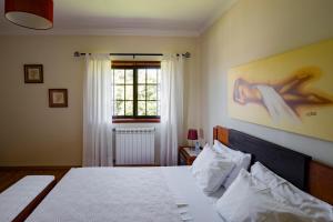 a bedroom with a bed and a painting on the wall at Suite em Viana do Castelo in Viana do Castelo
