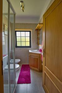 a bathroom with two sinks and a toilet and a window at Suite em Viana do Castelo in Viana do Castelo