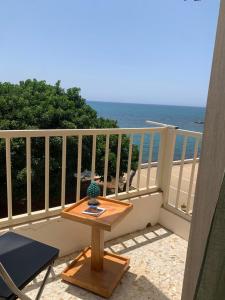 una mesa en un balcón con vistas al océano en MARE CELESTE APPARTAMENTO en Sciacca