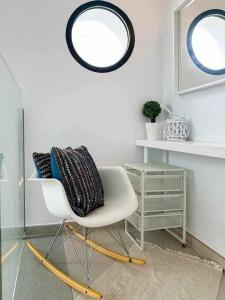 een kamer met een witte stoel en een spiegel bij Nice Nordic Style Villa 8 min from the beach. in El Campello