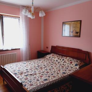 a bed in a bedroom with pink walls and a window at APPARTAMENTO OLGA in Massimeno