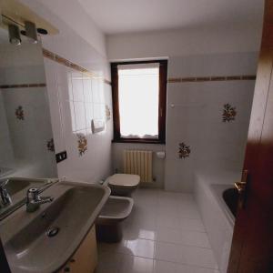 a bathroom with a sink and a toilet and a window at APPARTAMENTO OLGA in Massimeno