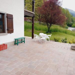 a patio with chairs and a table and a bench at APPARTAMENTO OLGA in Massimeno