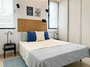 een slaapkamer met een groot bed met blauwe kussens bij Nice Nordic Style Villa 8 min from the beach. in El Campello