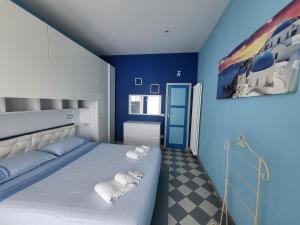 una camera blu con un letto e asciugamani di Tocco di mare a Porto Santo Stefano