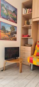 een woonkamer met een flatscreen-tv en een tafel bij La Casa del mare in Rosolina Mare +37 foto's