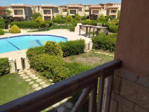 balcón con vistas a un patio con piscina en 4 bedroom Villa with private terrace, pool, and garden en Al Ḩammām