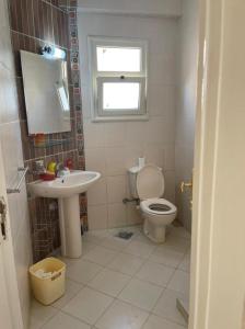 a bathroom with a toilet and a sink at 4 bedroom Villa with private terrace, pool, and garden in Al Ḩammām