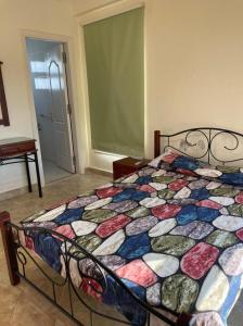 a bed with a colorful quilt in a bedroom at 4 bedroom Villa with private terrace, pool, and garden in Al Ḩammām