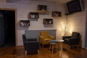 Cette chambre dispose de chaises, d'une table et d'une télévision. dans l'établissement Hôtel les Flocons, au Sauze