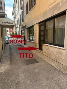 Un edificio con un cartel que dice "trío de pasas" en la acera. en Apartments TITO & ROBIN, en Koper