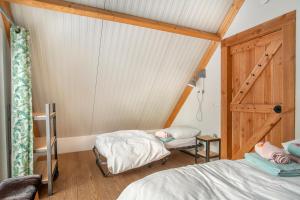 um quarto com duas camas, uma janela e uma porta em BoksheideBuiten em Eersel