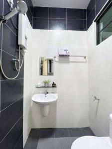 uma casa de banho com um lavatório e um WC em JJ&KK Homestay em Taiping