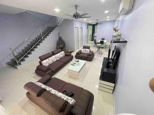 uma grande sala de estar com sofás e uma escadaria em JJ&KK Homestay em Taiping