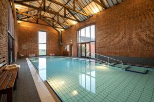a large swimming pool in a large brick building at End Cottage in Fakenham