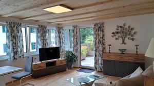 - un salon avec un canapé et une télévision dans l'établissement Haus Bergblick, à Altaussee