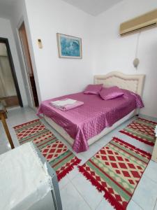 1 dormitorio con cama morada y alfombra en ATHERİNA BUTİK OTEL, en Kas