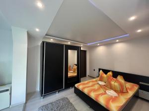 een slaapkamer met een groot bed met oranje kussens bij Casa Roland in Sovata