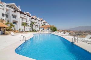 einen Pool in einem Resort mit Stühlen und einem Gebäude in der Unterkunft Calita 109 Mijas Costa - Málaga in La Cala de Mijas