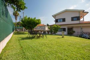 a yard with a table and chairs in front of a house at Suite em Viana do Castelo in Viana do Castelo +48 photos