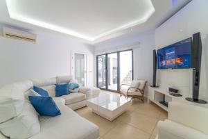 a living room with a white couch and a flat screen tv at Villa Sirmione in Playa Blanca