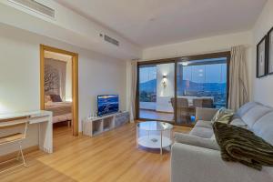 ラ・カラ・デ・ミハスにあるCalita 109 Mijas Costa - Málagaのリビングルーム(ソファ、テレビ付)、ベッドルーム1室が備わります。