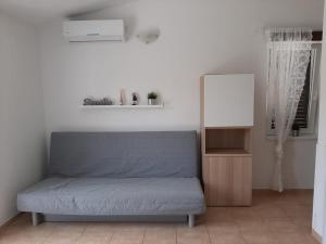 Sofá azul en una habitación con espejo en Pinezići apartman Niccole en Pinezici