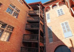 a brick building with balconies on the side of it at Duplex climatisé dans un monument historique in Toulouse