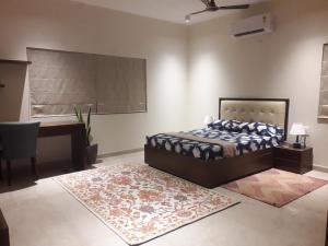 a bedroom with a bed and a desk and a table at Luho 125 in Bangalore
