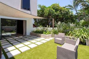 a garden with two chairs and a house at LIFESTYLE LIVING in Cape Town