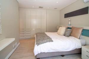 a bedroom with a bed with pillows on it at LIFESTYLE LIVING in Cape Town