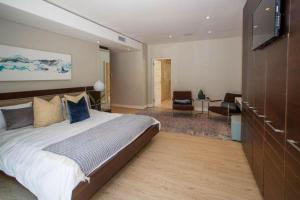 a bedroom with a large bed and a living room at LIFESTYLE LIVING in Cape Town
