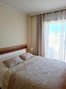 sypialnia z dużym łóżkiem i oknem w obiekcie Casa en Punta Prima w Alicante