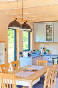 a kitchen with a wooden table and chairs in a kitchen at Lilla House in Sasino