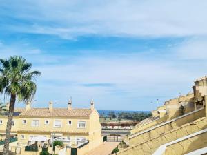 Blick auf ein Gebäude und eine Palme in der Unterkunft Casa en Punta Prima in Alicante