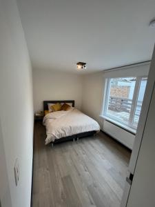 a bedroom with a bed and a large window at Westenwind in Ostend